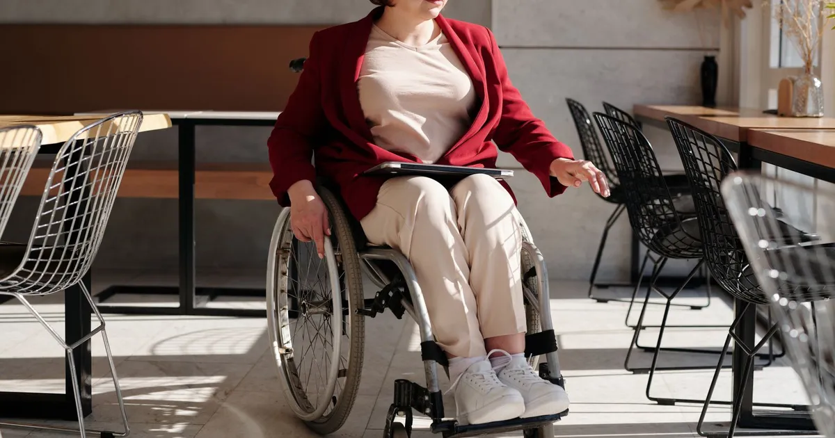 Person in a wheelchair comparing the best disability loans on a laptop at home in Canada