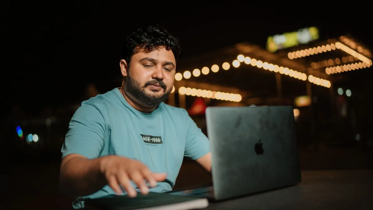 Person at a laptop in the evening completing an online loan application with bank verification