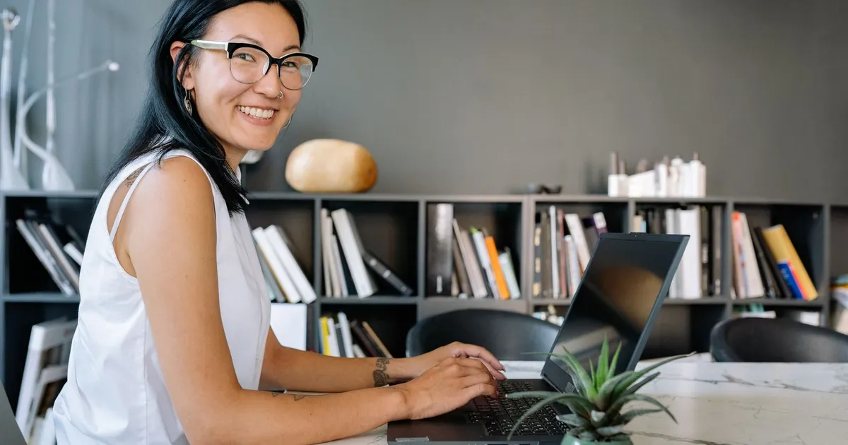 Person smiling at a laptop after comparing guaranteed loans bad credit lenders offer in Canada