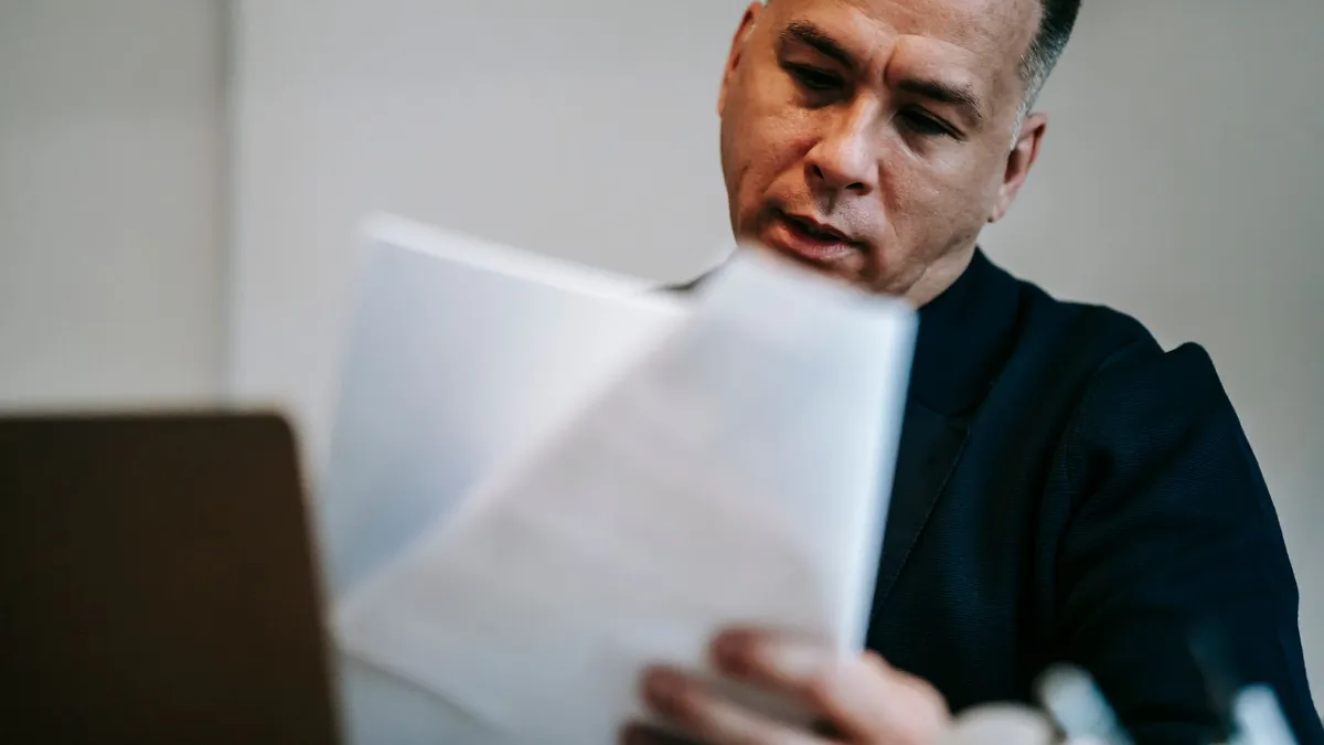 Man at home reviewing an EI deposit letter before applying for a loan